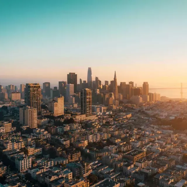 The skyline of 贝博体彩app is seen from the air in a golden light.